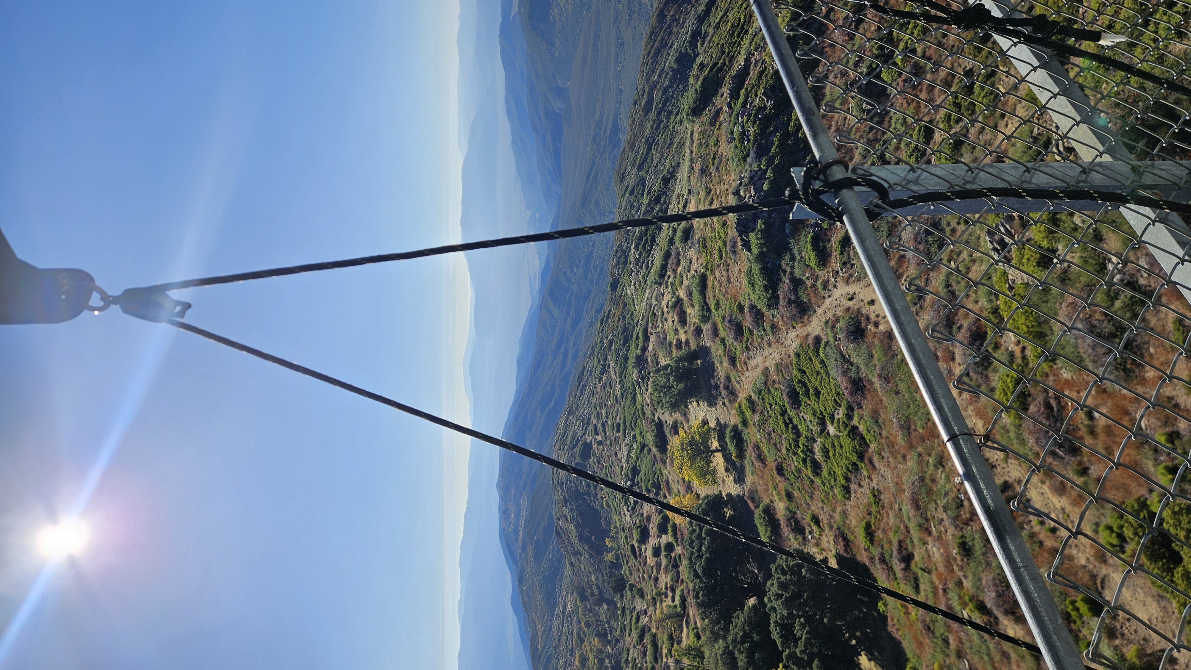 Looking straight down the tower: pulley rope, blue basket, water tank and solar array far below