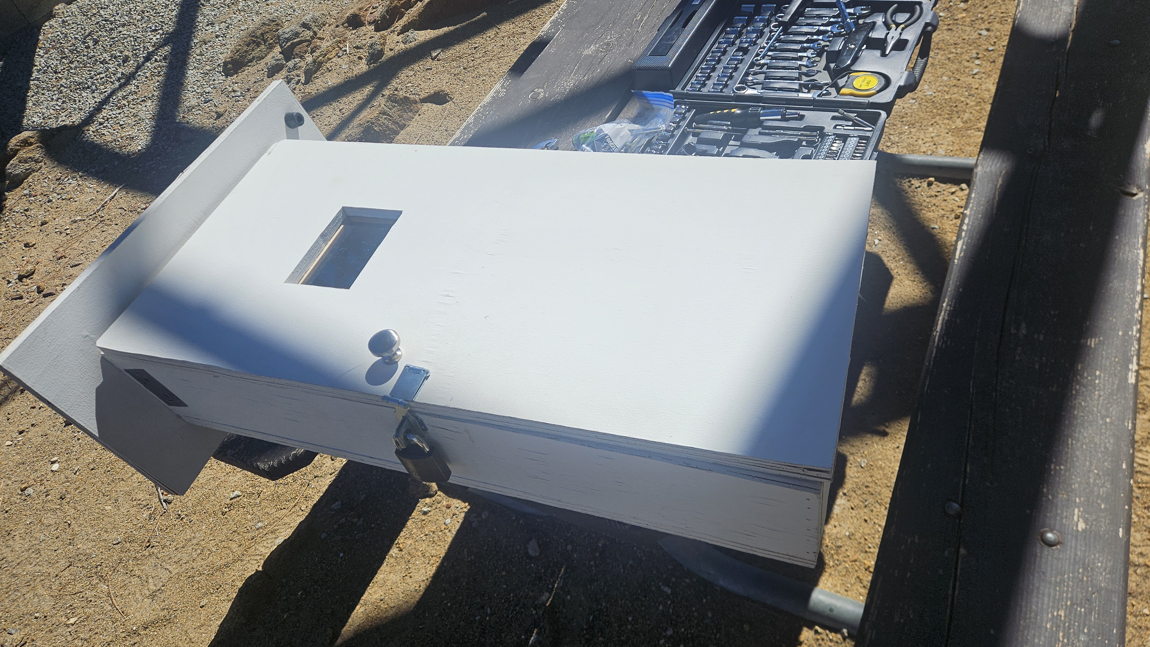 The fuel-stick cabinet taken off the pole and laid on the bench in the sun